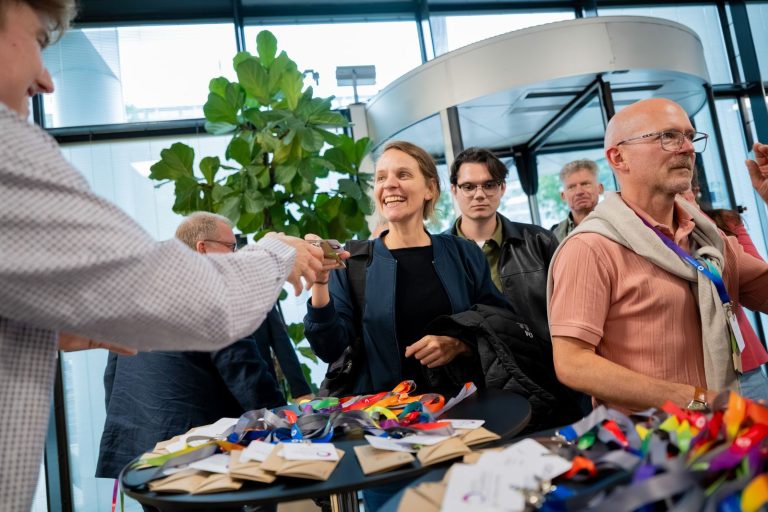 Gäste werden am Empfangstisch mit Namensbändern begrüßt