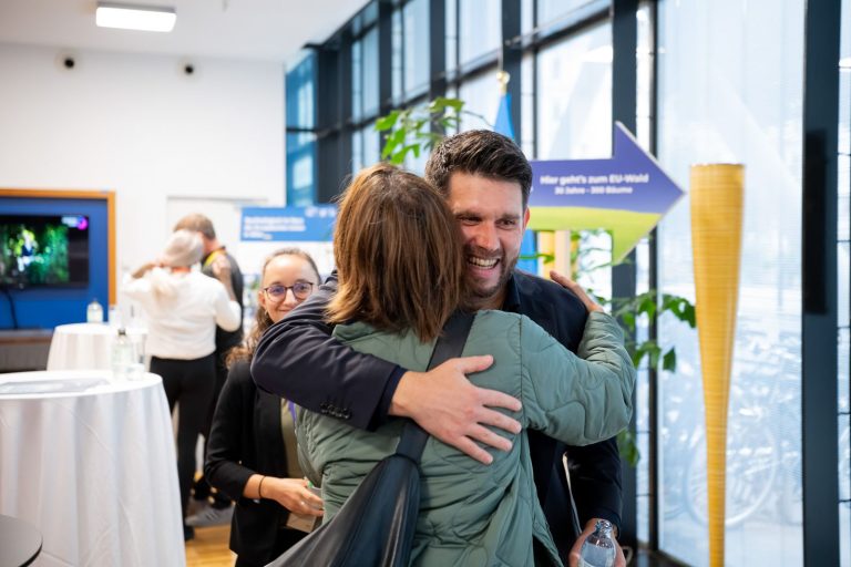 Mann und Frau umarmen sich zur Begrüßung im Foyer
