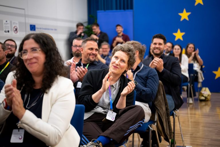Publikum applaudiert vor dem EU-Sternenkreis