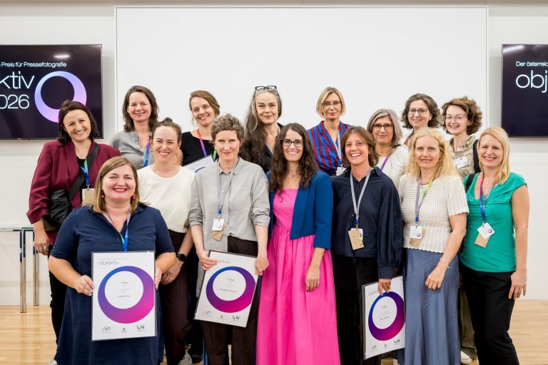 Gruppenfoto von Frauen, teils mit Urkunden, vor dem Objektiv-Bildschirm