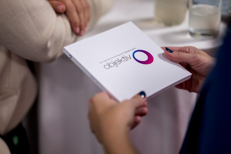 Hände halten die Broschüre „objektiv – Der österreichische Preis für Pressefotografie“